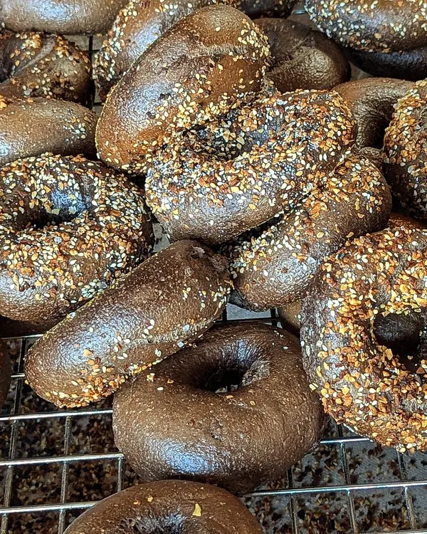 Dark seeded bagels cooling on a wire rack