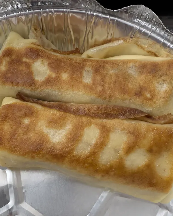 Golden cheese blintzes in a foil pan
