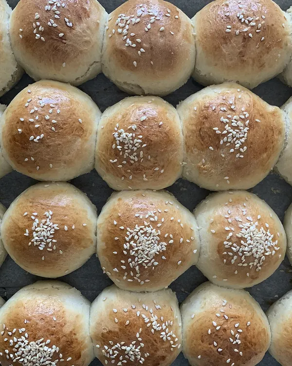 Tray of round egg buns topped with sesame seeds