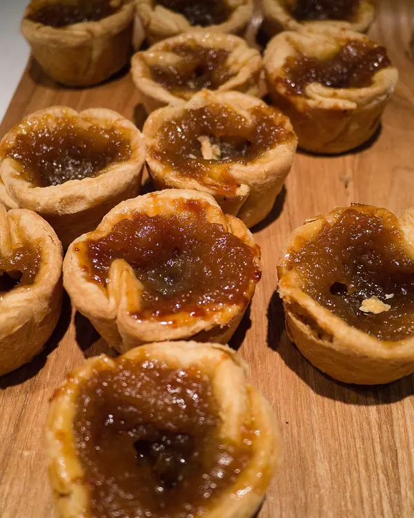 Butter tarts on a wooden cutting board