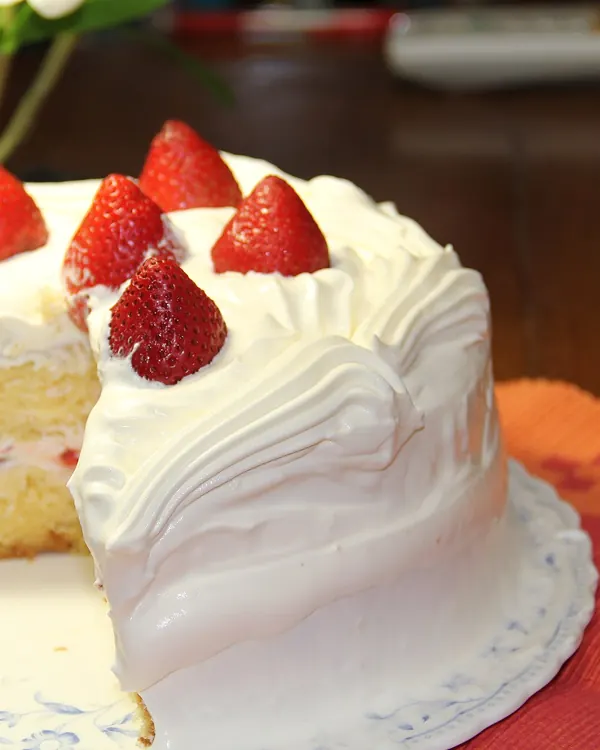Strawberry shortcake with whipped cream, one slice cut